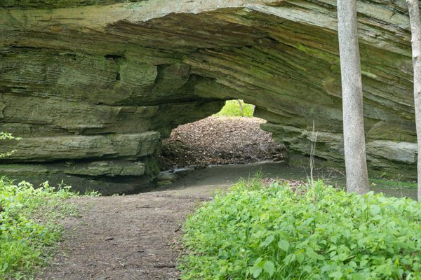 A wall of sandstone with a small opening 