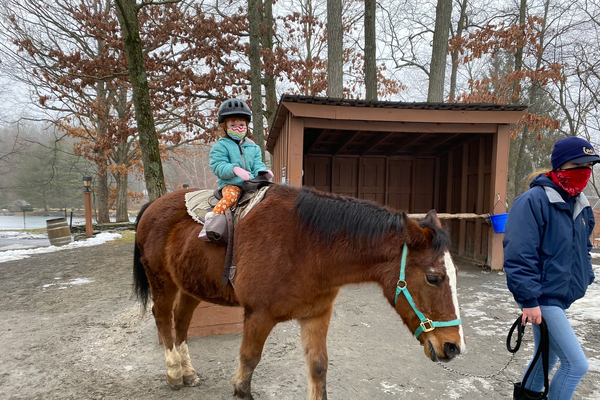 A child being led on a horse at Rocking Horse Ranch